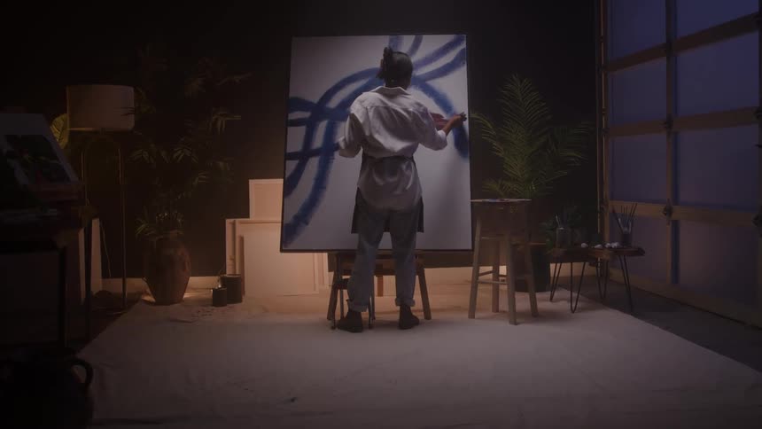 A woman paints on a canvas