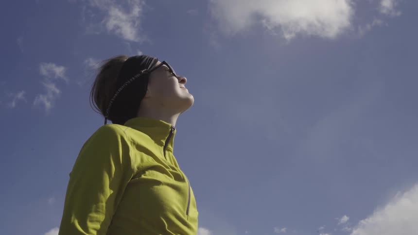 A woman looks up at the sky on a windy day