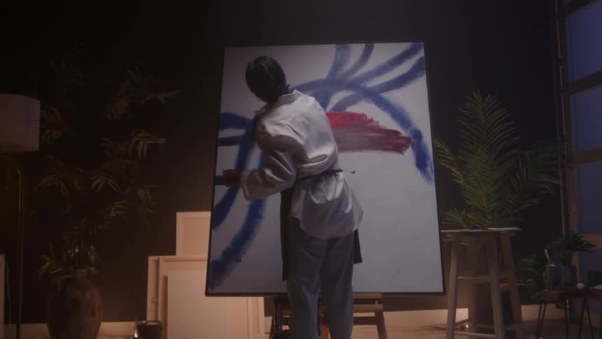A woman paints on a canvas