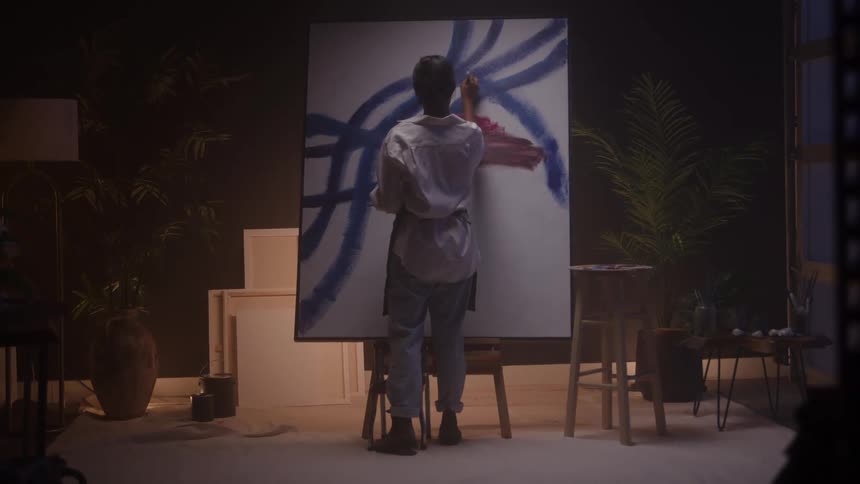A woman paints on a canvas