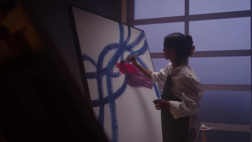The woman paints with red and blue colors