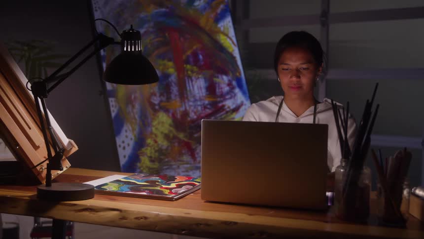 The woman is smiling in front of her laptop