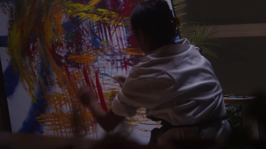 The artist wipes paint all over the canvas
