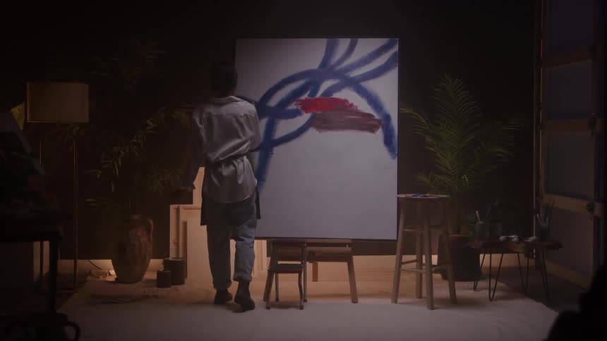 A woman paints on a canvas