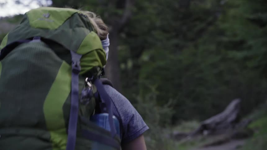 A woman is hiking on a windy day
