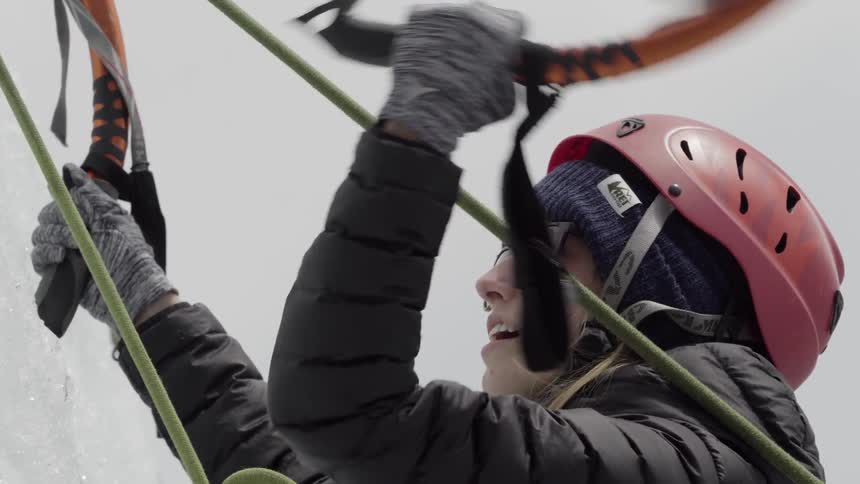 A woman is climbing up some ice