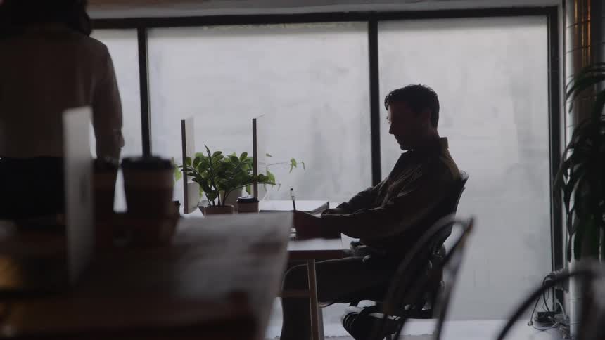A man and a woman sit opposite at a desk