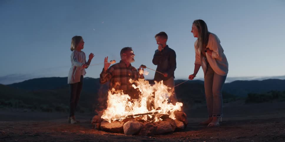Family gathered around a campfire at dusk