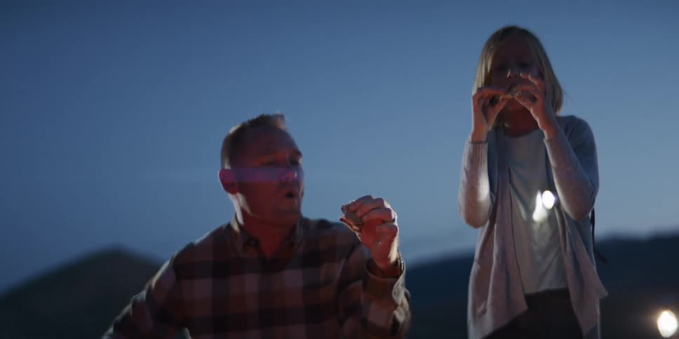 Father and daughter share a moment outdoors during twilight