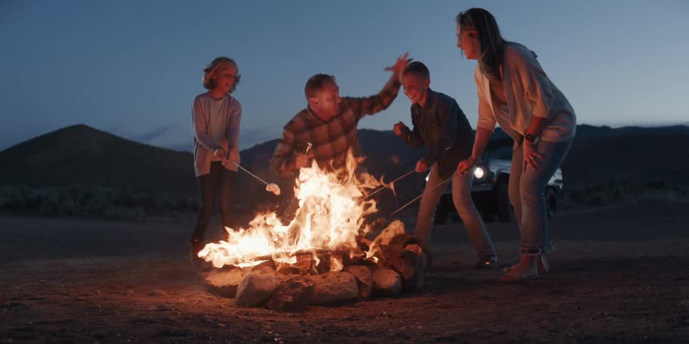 A group of people party around a bonfire