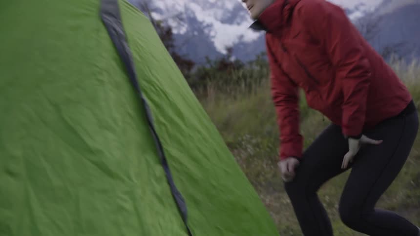A woman is setting up a tent