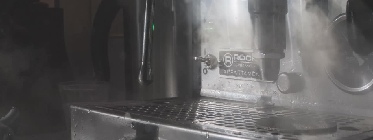 Close up of a person using an espresso machine