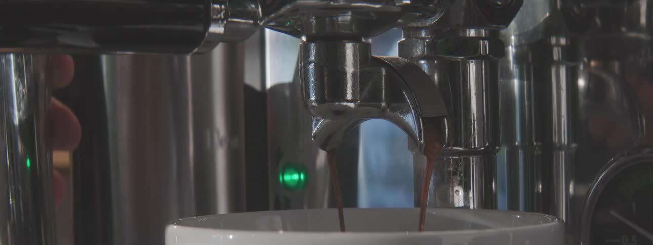 The person is making a cup of coffee with the machine
