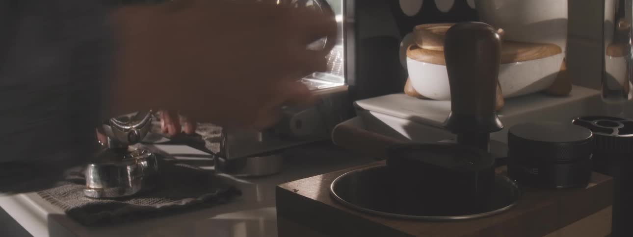 Closeup of hands preparing a portafilter before making espresso