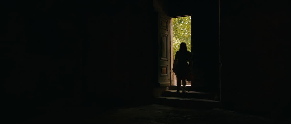 The woman enters the very dark room