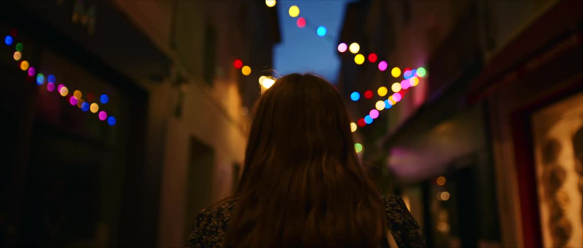 The woman walks through the dark alley
