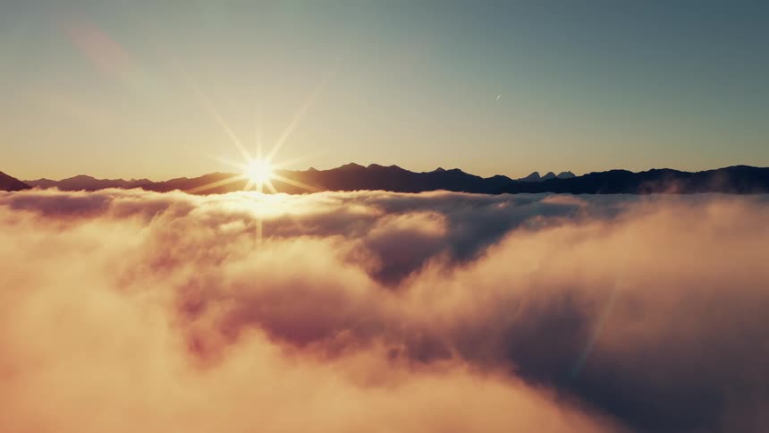 The sun is peaking out from behind the mountains as it rises
