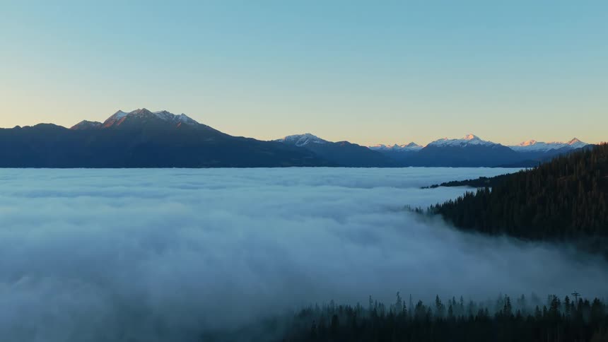 Snowy mountains above a sea of clouds at sunrise in Switzerland