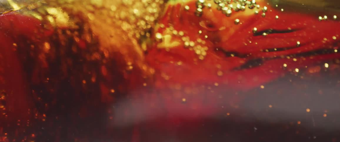 Amber bubbling liquid being poured in closeup