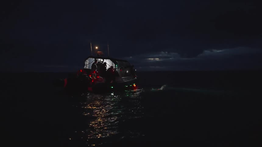 Fishermen work on the boat at night