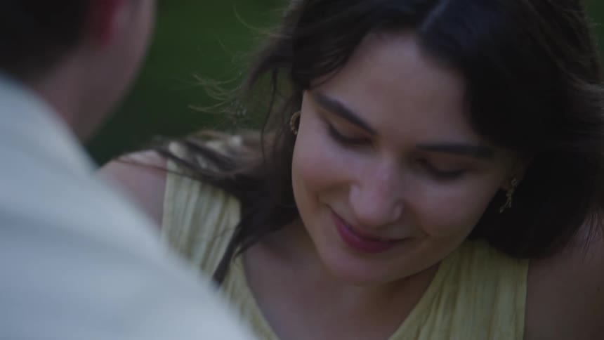 Man and woman smile at each other while on a date outdoors