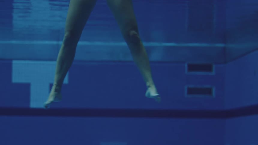 Female swimmer kicks while threading water in a swimming pool