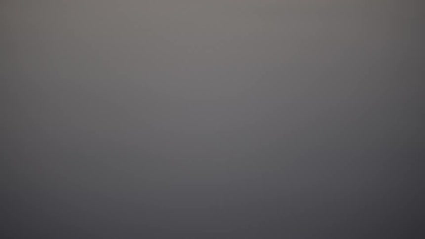 Blurred reflection of a person appears on the calm water surface