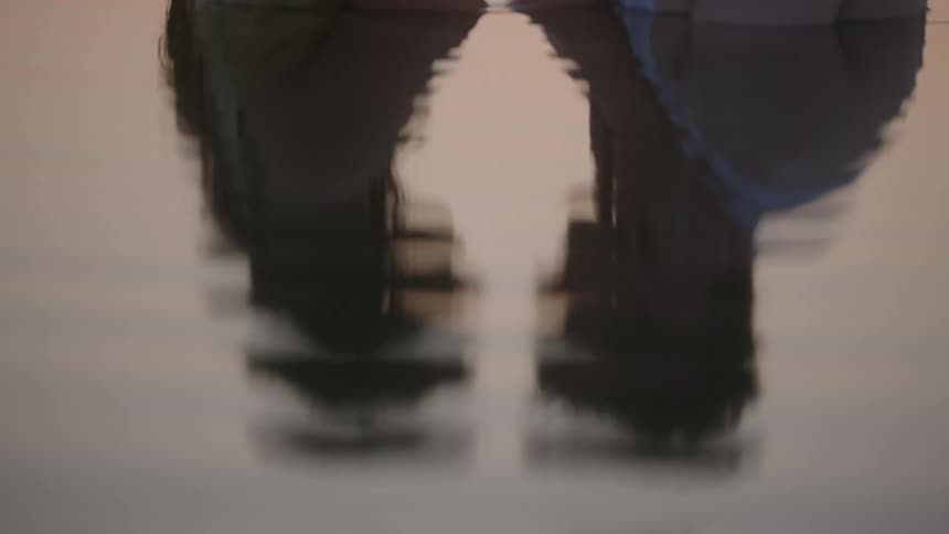 A couple kiss while standing in the water