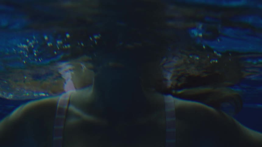 Woman treading water swims downward