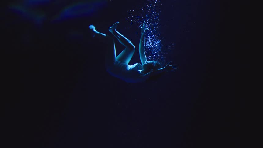 The woman is sinking in the dark water