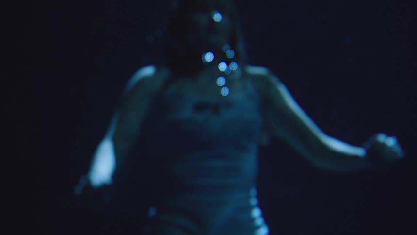 The girl slowly swims up underwater