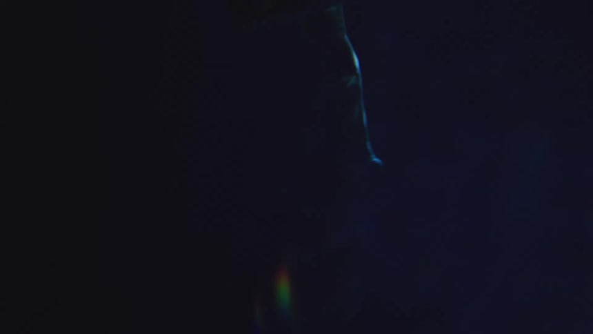 A womans feet glide through the dark ocean depths at night illuminated faintly by moonlight filtering through the water as gentle currents swirl around her