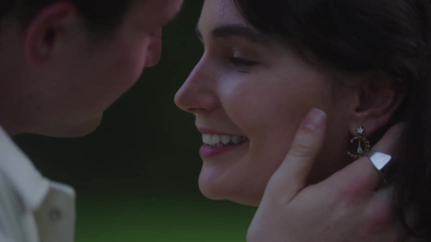 Couple shares a tender kiss in the soft light of dusk
