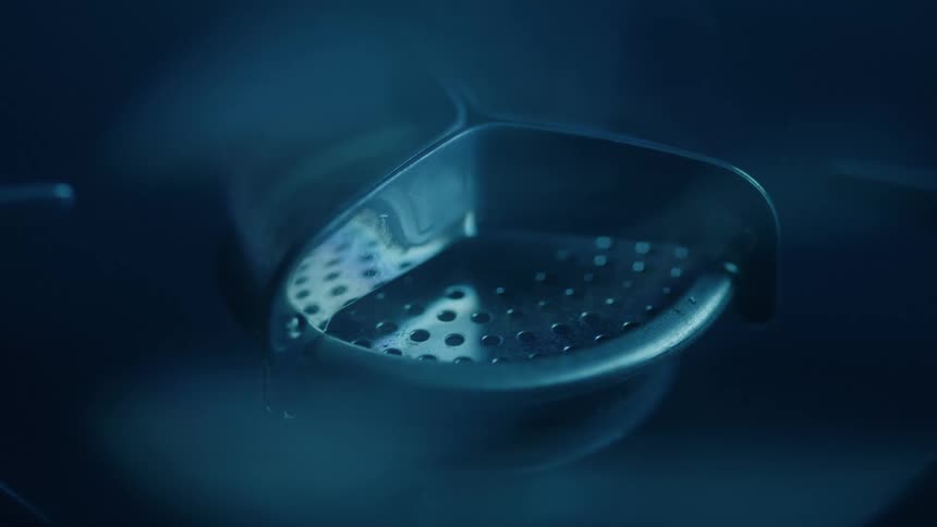 Blue flame heats metallic stove support under soft light