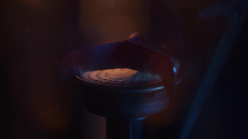 Espresso machine portafilter illuminated by soft orangetoned light