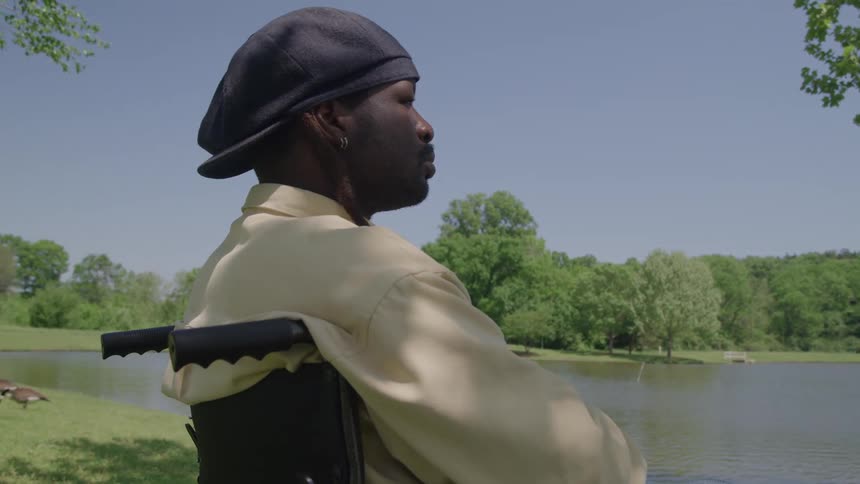 Man sitting by a lake gazes at the landscape under the clear sky