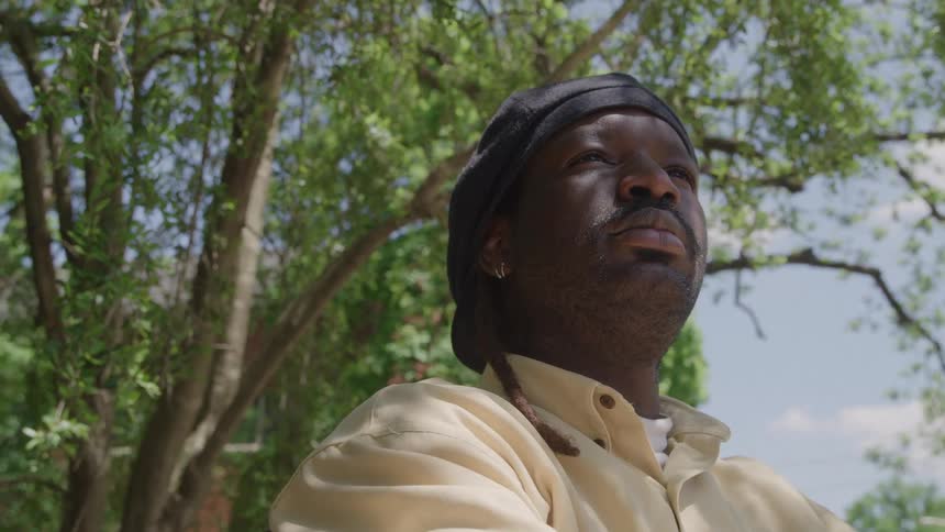 Close up portrait of a young black man standing outdoors during daytime