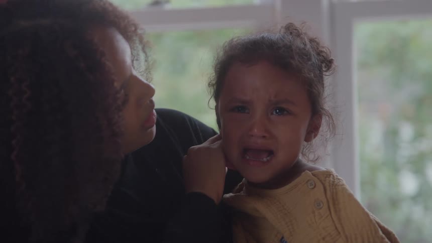 Mother comforting her crying daughter in her arms