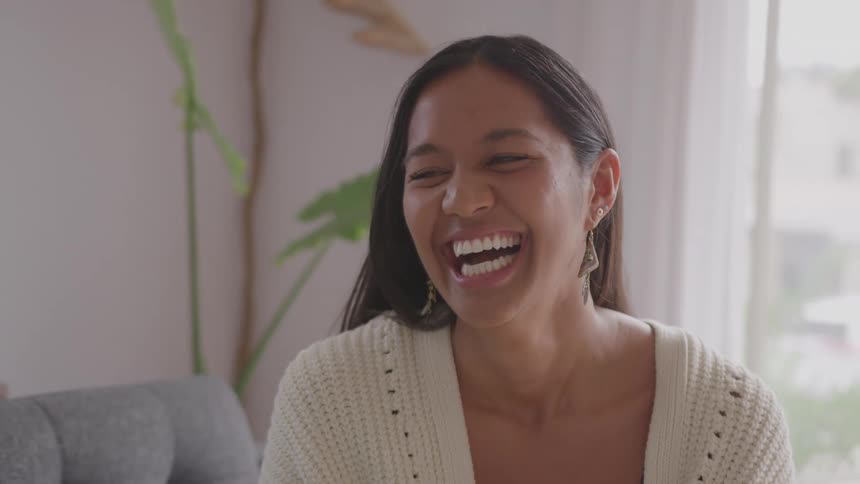 Smiling woman talks with someone in a bright and cozy setting