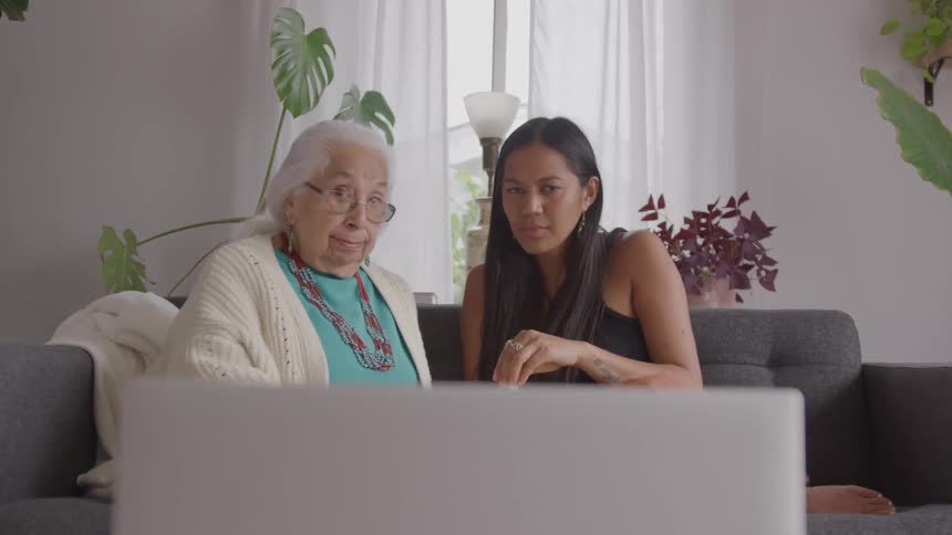 The women look interested in what they are watching on the laptop
