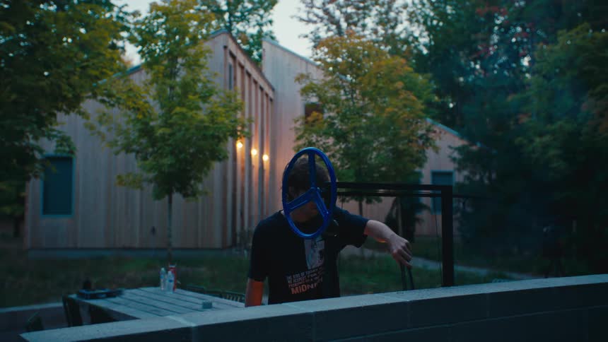 Man grilling at dusk in a treelined outdoor area