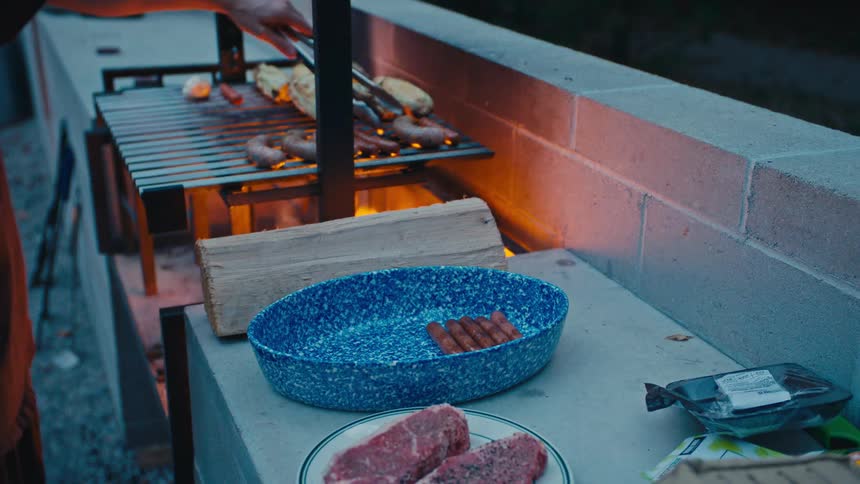 A man is grilling food on an open flame