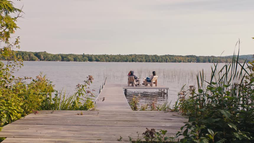 Two women talk on the pier on the lake
