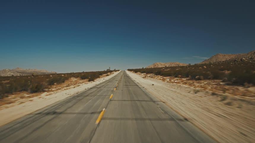 A long empty highway runs through the badlands