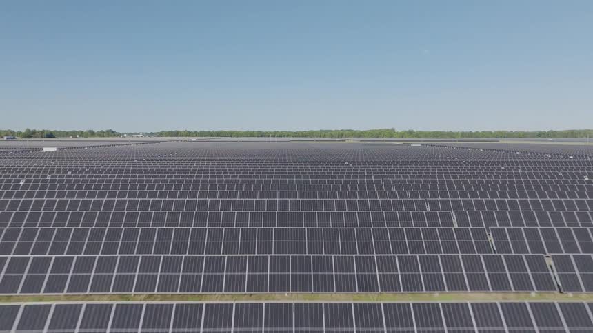 Vast area covered with solar panels stretches under the clear sky