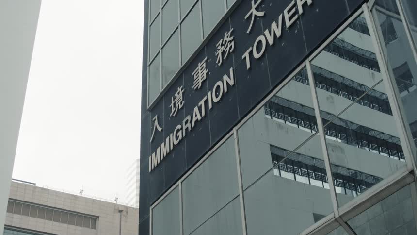 Glass faade of a building with the sign immigration tower prominently displayed