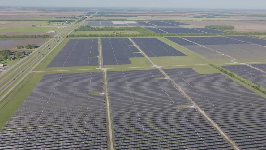 Solar energy plant next to a road with a natural landscape on the background outdoors during day time