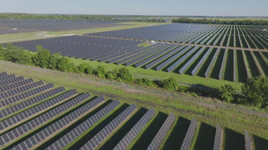 Vast area covered with solar panels aligned between strips of vegetation
