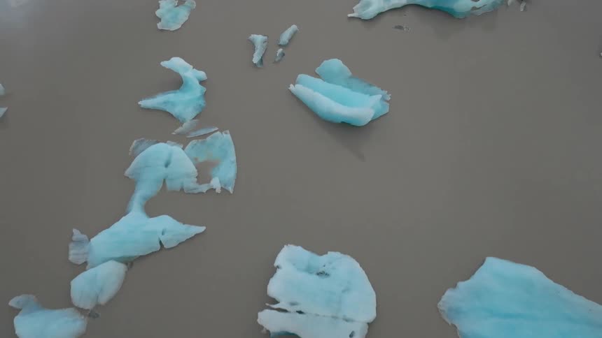 Wet beach soil scattered with ice during the day