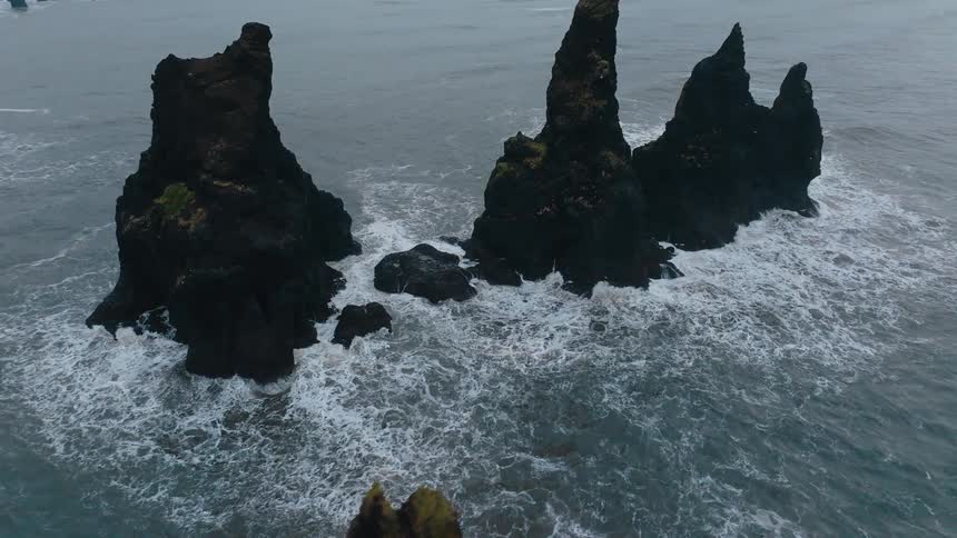 Aerial of waves crashing on rock formations in the ocean